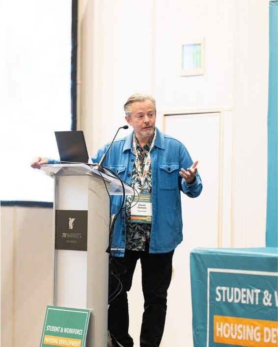 A speaker presenting a campus housing case study